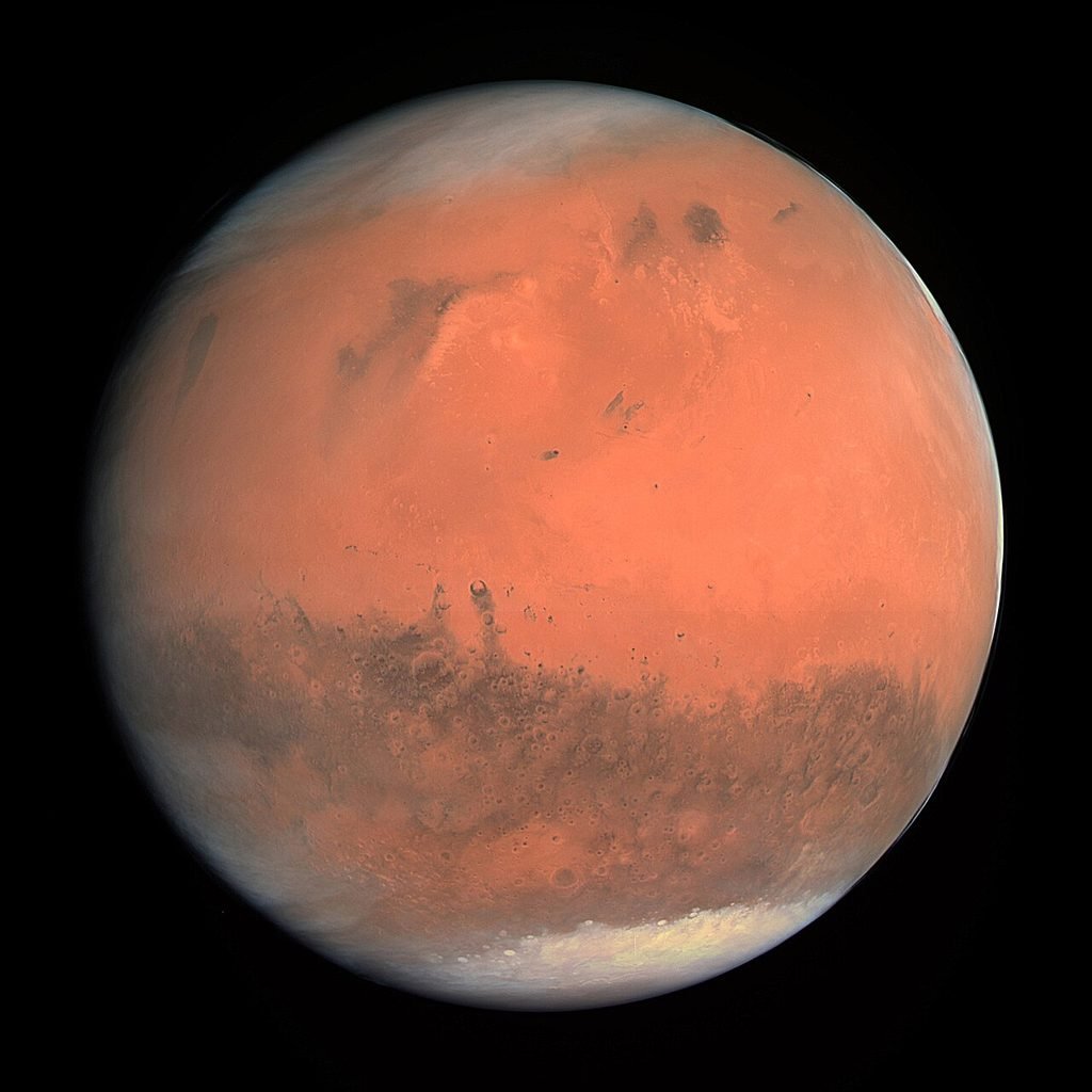 A high-resolution view of the rusty, red surface of planet Mars featuring a massive crater